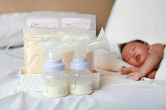 automatic-breast-pump-frozen-breast-milk-plastic-bag-bed-with-baby-sleeping