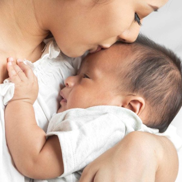 Portrait Of Enjoy Happy Love Family Asian Mother Playing With Ad Portrait of enjoy happy love family asian mother playing with adorable little asian baby.Mom kiss with cute son moments good time in a white bedroom.Love of family concept